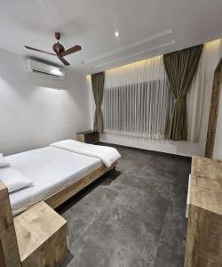 a bedroom with a bed and a ceiling fan at Curtis House in Hyderabad