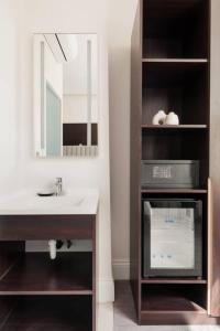 uma casa de banho com um lavatório, um espelho e um balcão em Rove Hotel London Paddington em Londres
