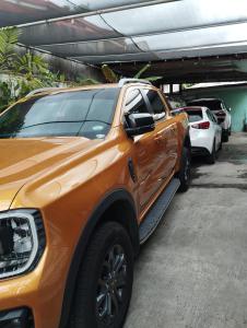 einem orangenen LKW, der auf einem Parkplatz parkt in der Unterkunft Virtuoso in Pasong Mannga