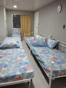 Zimmer mit 3 Betten in einem Zimmer in der Unterkunft Virtuoso in Pasong Mannga