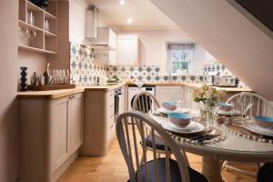 uma cozinha com uma mesa e cadeiras numa cozinha em Bughtrig Cottage em Coldstream