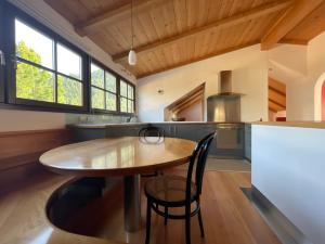 uma grande cozinha com uma mesa de madeira e cadeiras em Apartment Cesa Collina Superior em Ortisei