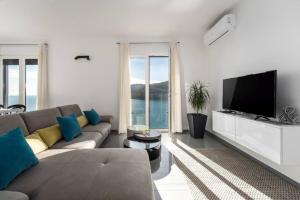 a living room with a couch and a flat screen tv at Astrid 2 in Rabac