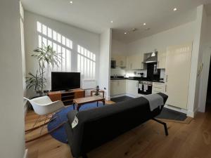 Il comprend un salon avec un canapé et une cuisine. dans l'établissement Delightful & Spacious Flat in London - Peckham, à Londres