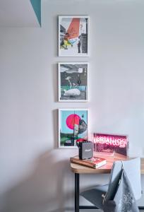 a room with a desk with pictures on the wall at URBAN LOFT Cologne in Cologne