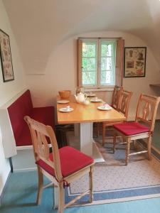 ein Esszimmer mit einem Holztisch und Stühlen in der Unterkunft Ferienwohnung Ottmanach Schlosshof in Pischeldorf