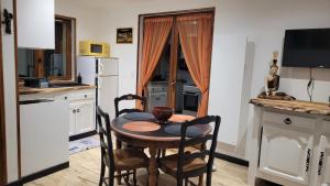 eine Küche mit einem Tisch und Stühlen in der Unterkunft Aux Nobles Acacias in Épagne-Épagnette
