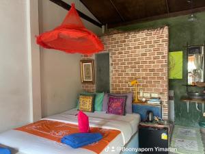 Artist's Place Trat في ترات: غرفة نوم مع سرير مع وسائد ملونة