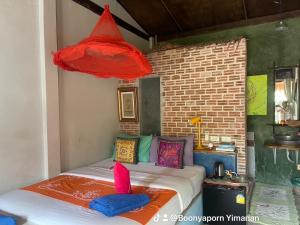 1 dormitorio con 1 cama con almohadas coloridas en Artist's Place Trat, en Trat