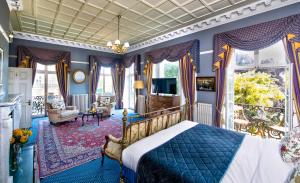 a bedroom with a bed with blue walls and windows at The Central Hotel in Scarborough