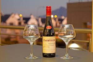 Una botella de vino y dos copas en una mesa. en Seaside Village by HostAgents en Ciudad del Cabo