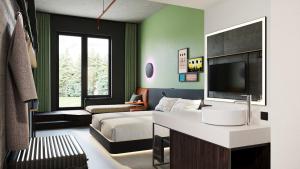 a bedroom with a bed and a television in a room at REVERB by Hard Rock Hamburg in Hamburg