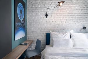 a bedroom with a white brick wall and a bed and a desk at URBAN LOFT Cologne in Cologne +28 photos