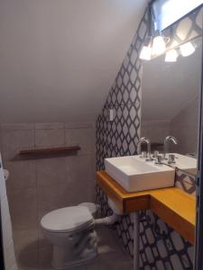 y baño con lavabo y aseo. en Las Cuatro Estaciones en Villa Cura Brochero