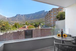 einen Balkon mit einem Tisch und Bergblick in der Unterkunft The Cedar Unit 101 in Kapstadt