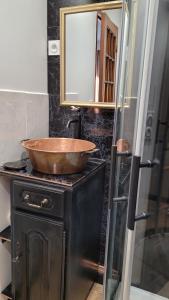 ein Badezimmer mit einer hölzernen Schüssel auf einem Waschbecken in der Unterkunft Aux Nobles Acacias in Épagne-Épagnette