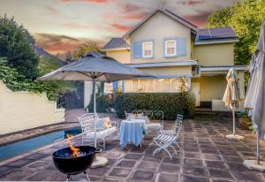 a patio with a table and an umbrella at The Rose Cottage B&B in Dullstroom