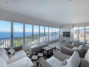 a living room with couches and a view of the ocean at Pinnacle Point Heritage Villa in Mossel Bay