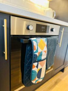a oven with towels hanging from the door of it at Spacious and Stylish Flat in Trowbridge, Wiltshire in Trowbridge