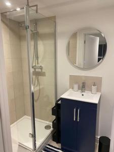 uma casa de banho com um chuveiro, um lavatório e um espelho. em Spacious and Stylish Flat in Trowbridge, Wiltshire em Trowbridge