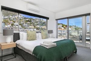 a bedroom with a bed with a green blanket at Seacliffe 502 by HostAgents in Cape Town