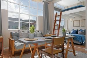 a living room with a table and a loft bed at Studio on Hope by HostAgents in Cape Town