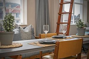 a dining room table with two wine glasses on it at Studio on Hope by HostAgents in Cape Town