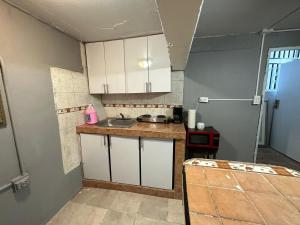 a small kitchen with white cabinets and a sink at 1BR Plus Basement, Near Beach and Restaurants in San Juan