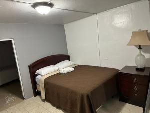 a bedroom with a bed and a table with a lamp at 1BR Plus Basement, Near Beach and Restaurants in San Juan