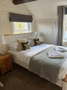 1 dormitorio con 1 cama blanca grande con almohadas en Babbling Brook Guesthouse en Keswick