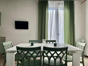 uma mesa de jantar com cadeiras e uma televisão em M'AMA apartment em Ficarazzi