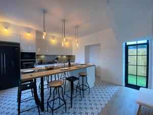 una grande cucina con ampia isola con sgabelli da bar di Casa 64 ad Angers