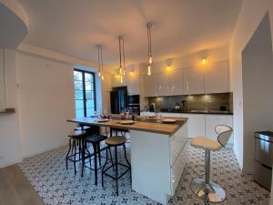 a kitchen with a island with bar stools at Casa 64 in Angers