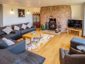 a living room with couches and a fireplace at Brambleberry Barn in Spilsby