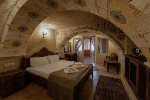 於爾居普的住宿－Capp Royal Cave HOTEL，一间带一张床铺的卧室,位于一个拱形的房间