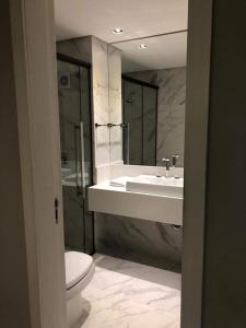 uma casa de banho com um WC, um lavatório e uma banheira em Estúdio novo com serviço de hotel em Florianópolis