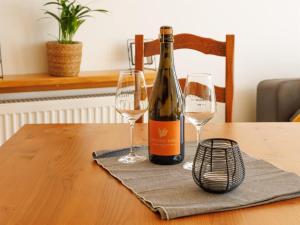 Una botella de vino y dos copas en una mesa. en Appartements im Weingut Frieden-Berg, en Nittel
