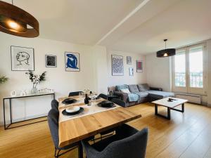 a living room with a table and a couch at L'horizon - Spacieux et idyllique t3 in Poitiers