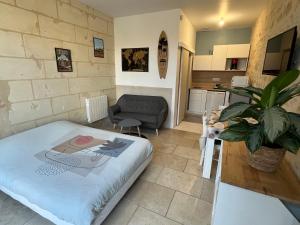 a small living room with a bed and a couch at Guest House de Céline et Benoît in Rivarennes