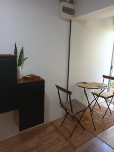 a room with two chairs and a table and a refrigerator at Leia's House in Colonia del Sacramento