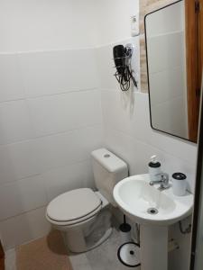 a white bathroom with a toilet and a sink at Leia's House in Colonia del Sacramento