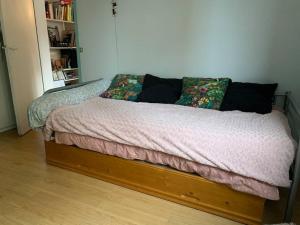 Appartement calme - Parking - Métro في إيفري سور سين: سرير بإطار خشبي في غرفة النوم
