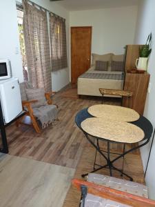 a living room with two tables and a bed at Leia's House in Colonia del Sacramento