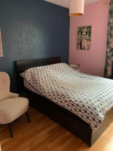 - une chambre avec un lit et une chaise dans l'établissement Appartement calme - Parking - Métro, à Ivry-sur-Seine