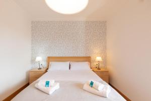 1 dormitorio con 1 cama con 2 almohadas blancas en Santuiturri - baskeyrentals, en Zarautz
