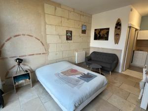a small bedroom with a bed and a couch at Guest House de Céline et Benoît in Rivarennes