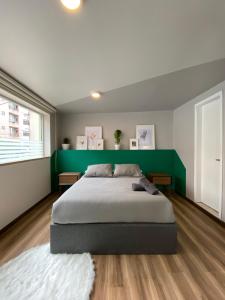een slaapkamer met een groot bed met een groen hoofdeinde bij CASA COLIV-BRI in Bogota