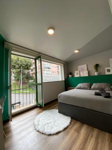 een slaapkamer met een bed en een groot raam bij CASA COLIV-BRI in Bogota