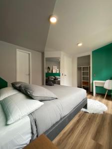 een slaapkamer met een groot bed en een groene muur bij CASA COLIV-BRI in Bogota