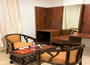 a living room with a table and a chair and a table and a coffee table at HOTEL AIRPORT PALACE in New Delhi